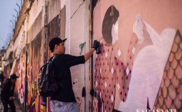 Salah satu street artist sedang berkarya di tembok Jalan Jend. Sudirman di seberang Roemah Seni Sarasvati
